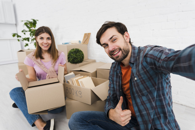 young-couple-moving-together-new-house-unpacking-cardboard-boxes-taking-sulfide_23-2148095510